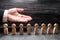 Businessman showing his hand to the wooden figures of people