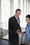 Businessman Showing Woman Cellphone In Airport