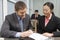 Businessman Signing Contract With Asian Businesswoman