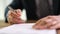 Businessman signing document contract with ballpoint pen in office closeup