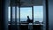 Businessman silhouette resting sea dark office. Intern taking break at window