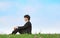 Businessman sits on grass, view in profile
