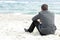 Businessman sitting on the beach alone