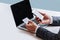 Businessman sitting behind desk, making money transaction on his phone at office