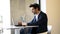 Businessman sitting in cafe, drinking fresh coffee typing with his laptop.