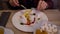 Businessman sitting in cafe pour tea into a white mug. Man eating a dessert in the restaurant. Person`s hands with fork