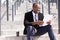 Businessman sitting with coffee and documents handling