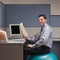 Businessman sitting on exercise ball at desk