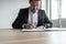 Businessman sitting at his desk signing a document