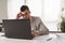 Businessman sitting on his office desk. Analysing reports, worried