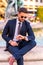 A businessman sitting next to a fountain and checking the time