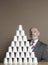 Businessman Sitting BY Pyramid Of Cups