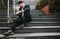 Businessman sitting on steps laptop and coffee