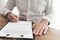 Businessman sitting at wooden desk signing document or contract