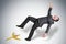 Businessman slipping and falling from a banana peel