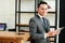 businessman smiling and holding a tablet while lean back at table