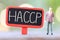 Businessman stand near wooden sign of HACCP Text.