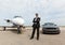 Businessman Standing By Car And Private Jet At