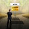 Businessman standing on a crossroad, having to choose the right path what to do with the words shares, sell and buy