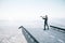 Businessman standing on a destroyed bridge with telescope