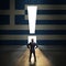 Businessman standing in front of a portal shaped as a exclamation mark in a wall painted with greek flag