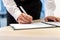 Businessman standing at his office desk signing a report