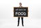 Businessman standing and holding blackboard with words `will work for food` written on it