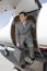 Businessman Standing On Ladder Of Private Airplane