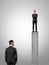 Businessman standing on peak of a concrete pillar looking at the other businessman