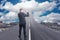 Businessman standing on road that goes up to the sky