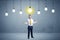 Businessman standing uninspired with bulbs above