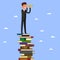 Businessman stands on stack of books.