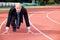 Businessman at the start line of running track