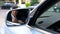 Businessman straightening shirt, ready for meeting, reflection in wing mirror