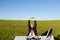 Businessman Stretching At Desk On Grassy Field Against Sky