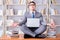 Businessman student in lotus position meditating with a laptop i