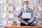 Businessman student in lotus position meditating with a laptop i