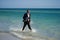 Businessman suit barefoot running on beach. Handsome business man on summer vacation. Businessman running on sea holding