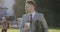 A businessman in a suit is drinking coffee against the background of fountains in the city.