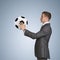 Businessman in suit hold soccer ball