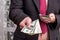 Businessman in suit offer dollar banknotes, close up