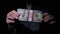 Businessman in Suit Shows Stack of 10000 American Dollars on Black Background