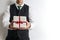Businessman in suit vest holding a Christmas gift / present.