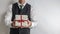 Businessman in suit vest holding a Christmas gift / present.