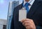 Businessman in suit wearing a blank ID tag or name card on a lanyard at an exhibition or conference