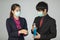 Businessman in suit and wearing protective hygiene mask help his friend to pour alcohol gel on for wash and sterilize hands for