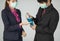 Businessman in suit and wearing protective hygiene mask help his friend to pour alcohol gel on for wash and sterilize hands for