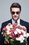 Businessman in sunglasses holding flowers