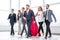 Businessman in Superman cloak and business team standing in office lobby