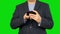 Businessman surfing the smartphone Alpha channel, keyed green screen.